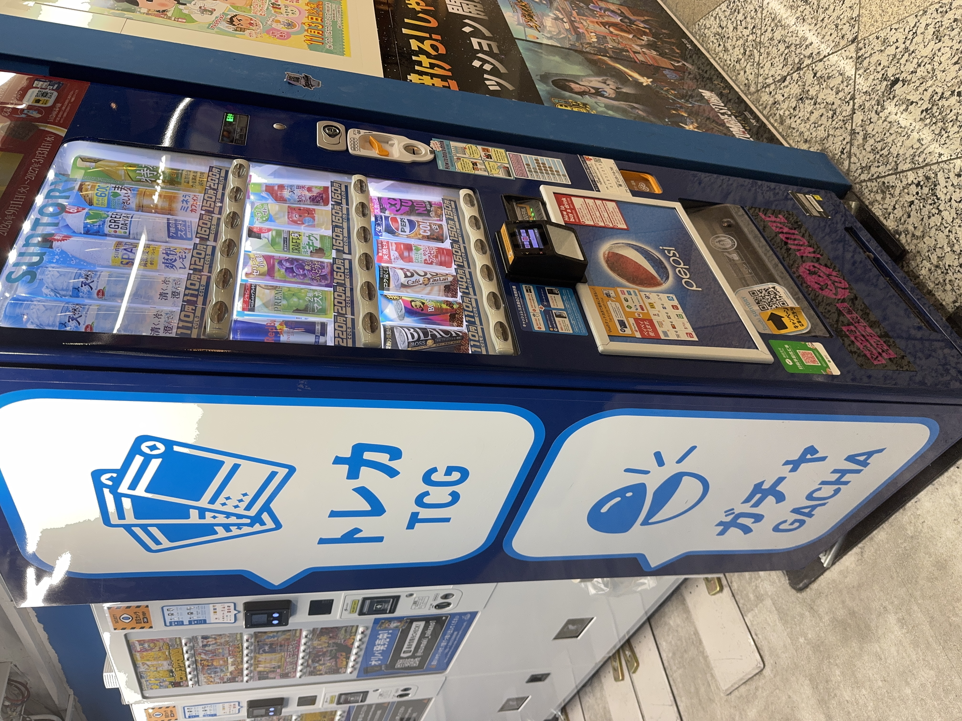 トレカとガチャのイラストが大きく描かれた自動販売機
